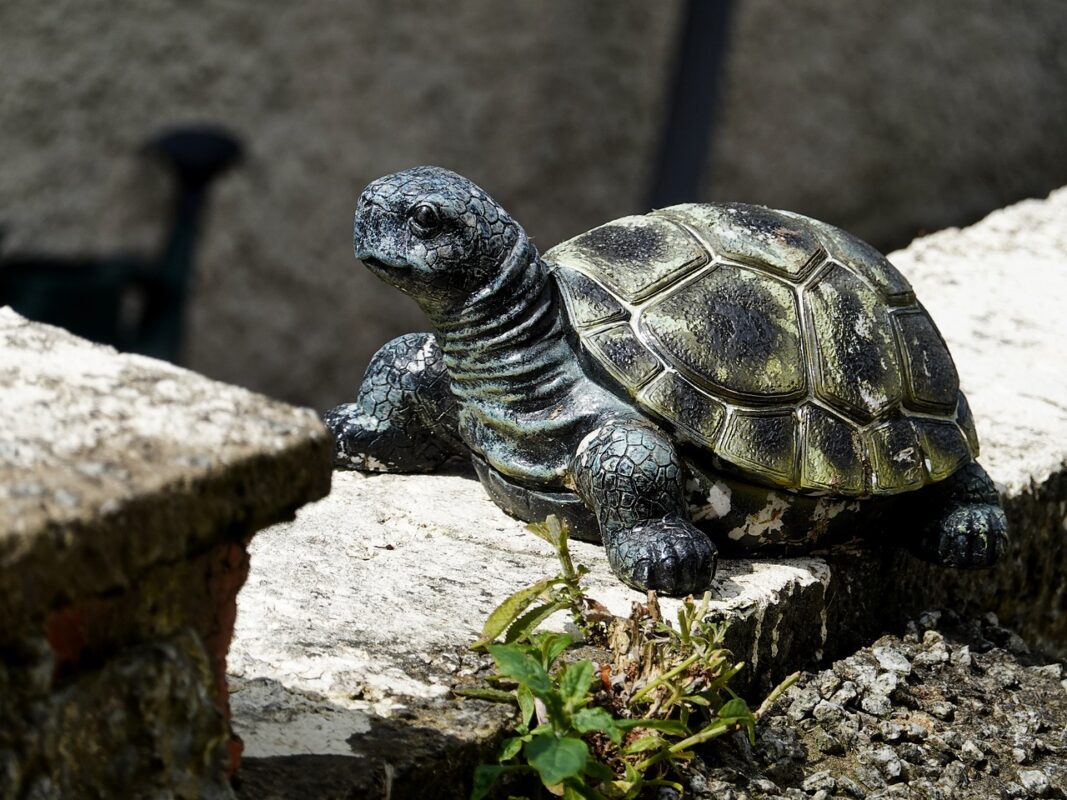 A weathered garden statue being cleaned before repainting